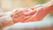 © Renán Vicencio Uribe - primer plano de mano de mujer joven tomando la mano de anciana. Ambiente cálido e iluminación suave