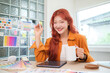 © wattana - Cheerful young graphic designer with red hair holding a coffee mug working at creative office.