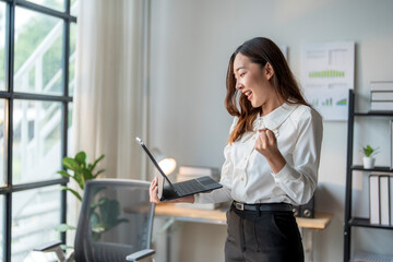 Wall Mural - businesswoman celebrating success looking at tablet in office