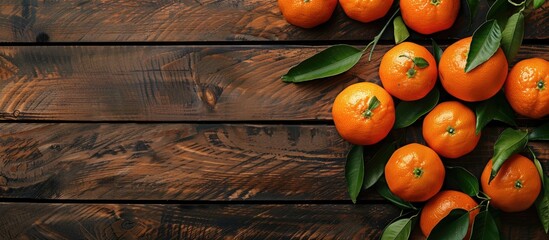 Wall Mural - Fresh mandarin oranges displayed with leaves on a wooden table, providing a copy space image.