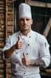 © Pter - realistic portrait of a handsome brutal male chef shows a thumbs up