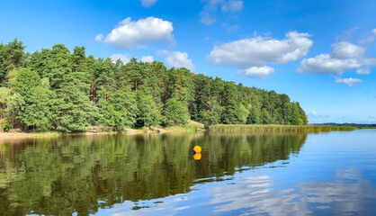 Panorama of blue sky with small cumulus clouds over beautiful Kisezers lake - one of the largest freshwater lakes with access in Baltic Sea. Riga, Latvia