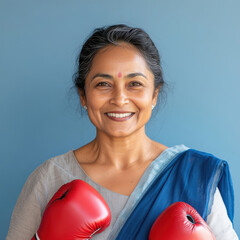 Happy indian middle age woman wearing red color boxing gloves