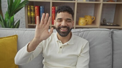 Sticker - Young hispanic man at home, smiling and saying hi with a friendly gesture, welcoming a happy hello