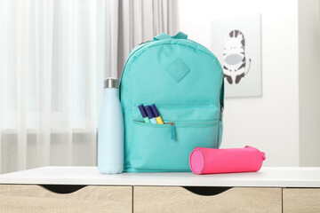 Canvas Print - Backpack with different school stationery and bottle on desk in room