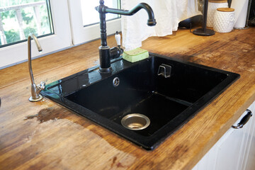 the process of cleaning a black kitchen sink