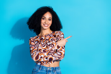 Poster - Photo of cheerful adorable woman wear stylish print clothes demonstrate empty space news isolated on blue color background