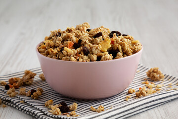 Healthy Homemade Muesli with Fruits in a Pink Bowl, side view.