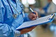 © Yuliia - Close-up shot of a nurse's hands holding a clipboard and pen, making notes and checking off items on a checklist during a patient consultation. The focus is on the healthcare service