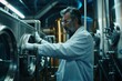 © jureephorn - A middle-aged, talented brewery worker wearing a white coat and protective gloves controls the beer fermentation process as he works.