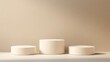 © liliyabatyrova - Three elegant white pedestals create a harmonious display, set against a soothing beige background, inviting contemplation and creativity in design