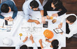 © Summit Art Creations - Top view banner of diverse group of civil engineer and client working together on architectural project, reviewing construction plan and building blueprint at meeting table. Prudent