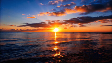 Wall Mural - A beautiful sunset over a calm ocean with the sun dipping below the Horizon