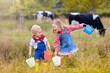 © famveldman - Kids watch cow on dairy farm