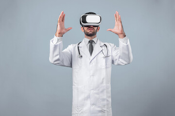 Caucasian doctor looking medical data while using VR goggles to connect metaverse. Skilled doctor standing while holding and pointing at something while wearing lab coat and visual reality. Deviation.