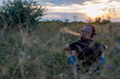 © mihakonceptcorn - A young man with a beard and a mohawk in a field at sunset.