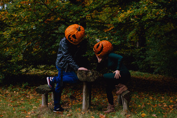 A young couple posing in pumpking head jack o lantern costumes