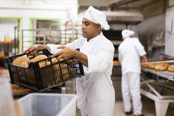 Wall Mural - Male baker with box of hot bread at bakery