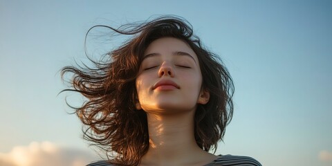 Poster - young woman with eyes closed standing with her hair in the wind breeze