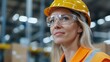 © top images - A woman wearing a yellow helmet and safety glasses is standing in a warehouse