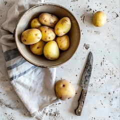 Wall Mural - Raw potatoes in a bowl on a light background, top view.