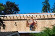 © knelson20 - View of new residential home construction over the asphalt roof of existing neighbor house, worker on wall working in window opening of OSB oriented strand board exterior wall, summer construction sea
