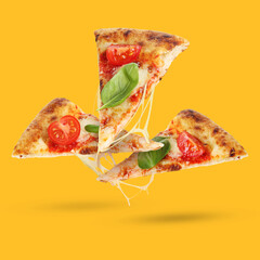 Slices of delicious pizza in air on orange background