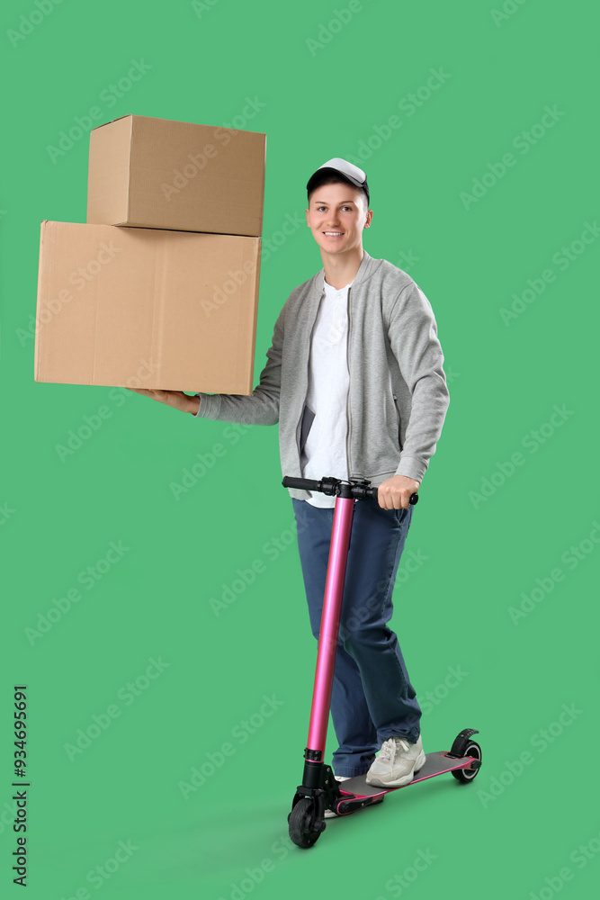 Male courier with big cardboard boxes and kick scooter on green background