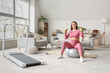 © Pixel-Shot - Sporty pregnant woman with dumbbells training on fitball at home