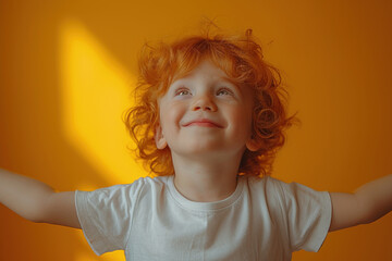 Wall Mural - Joyful red-haired child smiling against orange background