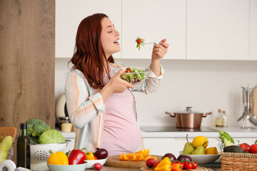 Poster - Young pregnant woman with fresh vegetable salad in kitchen