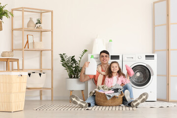 Sticker - Young father and his daughter with laundry basket sitting near washing machines in bathroom