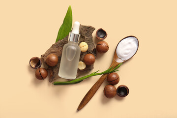 Wall Mural - Macadamia nuts, tree bark, wooden spoon and bottle of cosmetic product on beige background