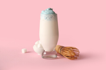 Canvas Print - Glass of blue dalgona matcha latte, sugar and whisk on pink background