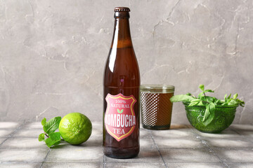 Wall Mural - Bottle of tasty kombucha tea with lime and mint on grey tile table