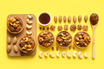 Wall Mural - Tasty tarts with many different nuts and caramel on yellow background