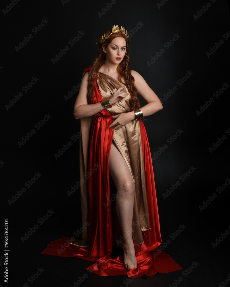 Full length portrait of beautiful female model wearing grecian red silk ...
