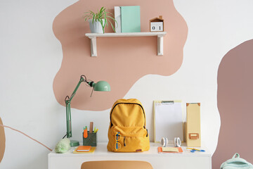 Sticker - Workspace with school supplies and backpack near color wall