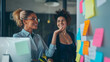 © Mahemud - Businesswomen discussing their ideas using sticky notes.