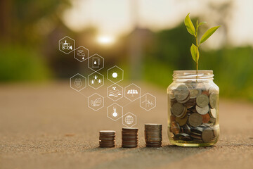 Saving money by hand puting coins in jug glass on nature background