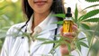 © stockdevil - Medical professional holding a bottle of CBD oil with a cannabis leaf background, cannabis, medical use