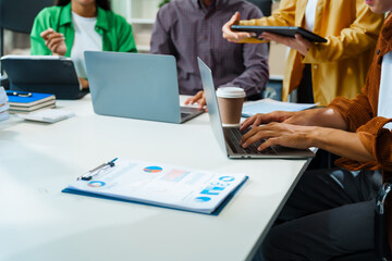 In a boardroom, an Asian team discusses startup financials and business terms. They present strategies on acquisitions, cash flow, and investor relations, innovative approaches for company growth.