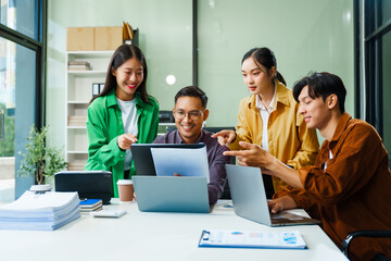 In a boardroom, an Asian team discusses startup financials and business terms. They present strategies on acquisitions, cash flow, and investor relations, innovative approaches for company growth.