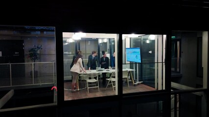 Aufkleber - Footage from Outside the Window: Managers and Specialists Having as Business Meeting in the Evening. Partners Discussing the Presentation with Analytics, Stats and Animated Reports