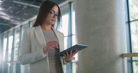 Poster - Successful Young Female Walking in a Modern Office Hall, Using a Tablet Computer. Manager on Her way to a Meeting, Preparing on the Go, Reading Data Online on Her Device, Communicating with Colleagues