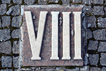 Building materials, memorials, beautiful, white inscriptions in gray and brown granite in the form of Roman numerals one, two, three, four, five, six, seven, eight, nine and ten.