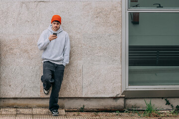 Poster - young university man on the street looking at the mobile phone with american urban styling