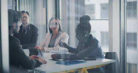 Aufkleber - African Female Manager Showing a Report to a Colleague while a Team Having a Discussion in an Office Meeting Room. Group of Businesspeople Analyzing Financial Reports,  Brainstorming New Ideas
