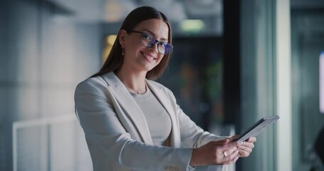 Poster - Portrait of a Happy Beautiful Woman Holding a Tablet Computer, Smiling while Standing in a Corporate Office and Looking at Camera. Female Manager Working on Financial, Business and Marketing Projects
