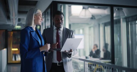 Poster - African Lawyer and a Young Female Attorney Standing in a Modern Office Building. Two Diverse Colleagues Going Through Schedule and Meetings With Clients on Laptop Computer in a Law Firm